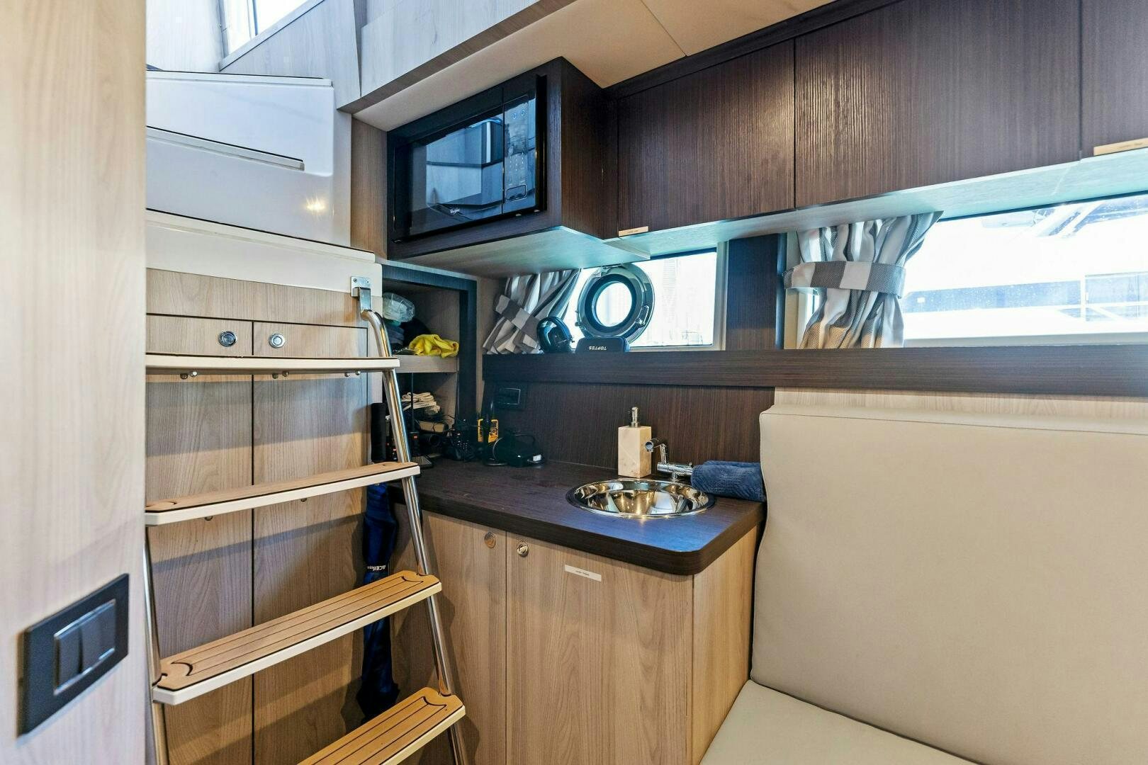 a kitchen with a sink and a microwave aboard LIMITLESS Yacht for Sale
