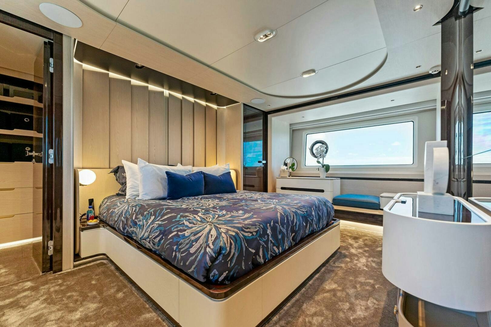 a bedroom with a bed and a desk aboard LIMITLESS Yacht for Sale