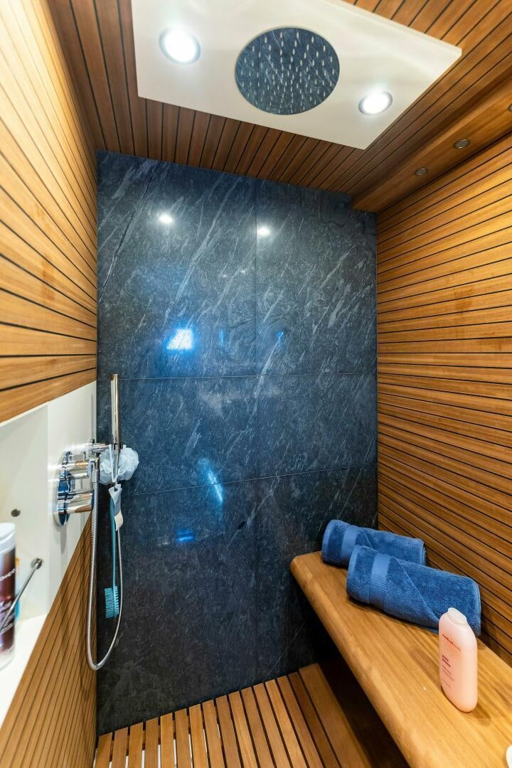 a room with a blue wall and a blue pillow on a table aboard LIMITLESS Yacht for Sale