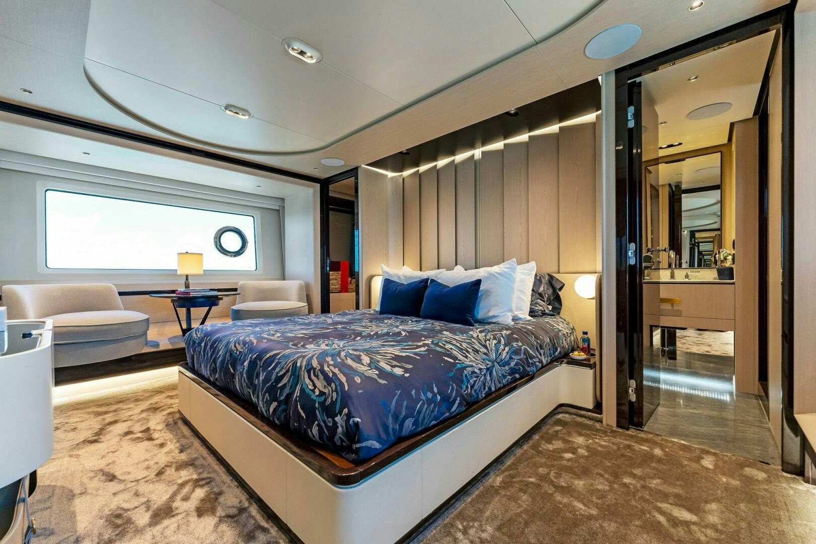 a bedroom with a bed and a large mirror aboard LIMITLESS Yacht for Sale