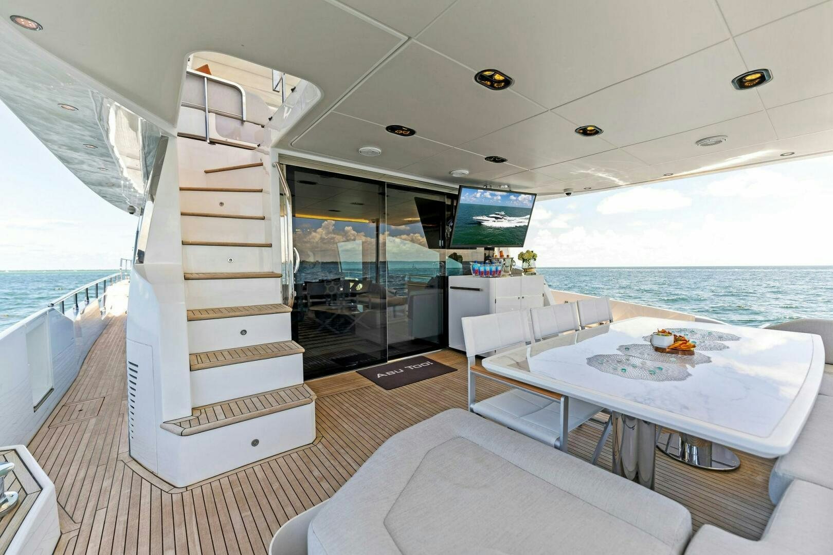 a room with a bed and a table and a large window aboard LIMITLESS Yacht for Sale