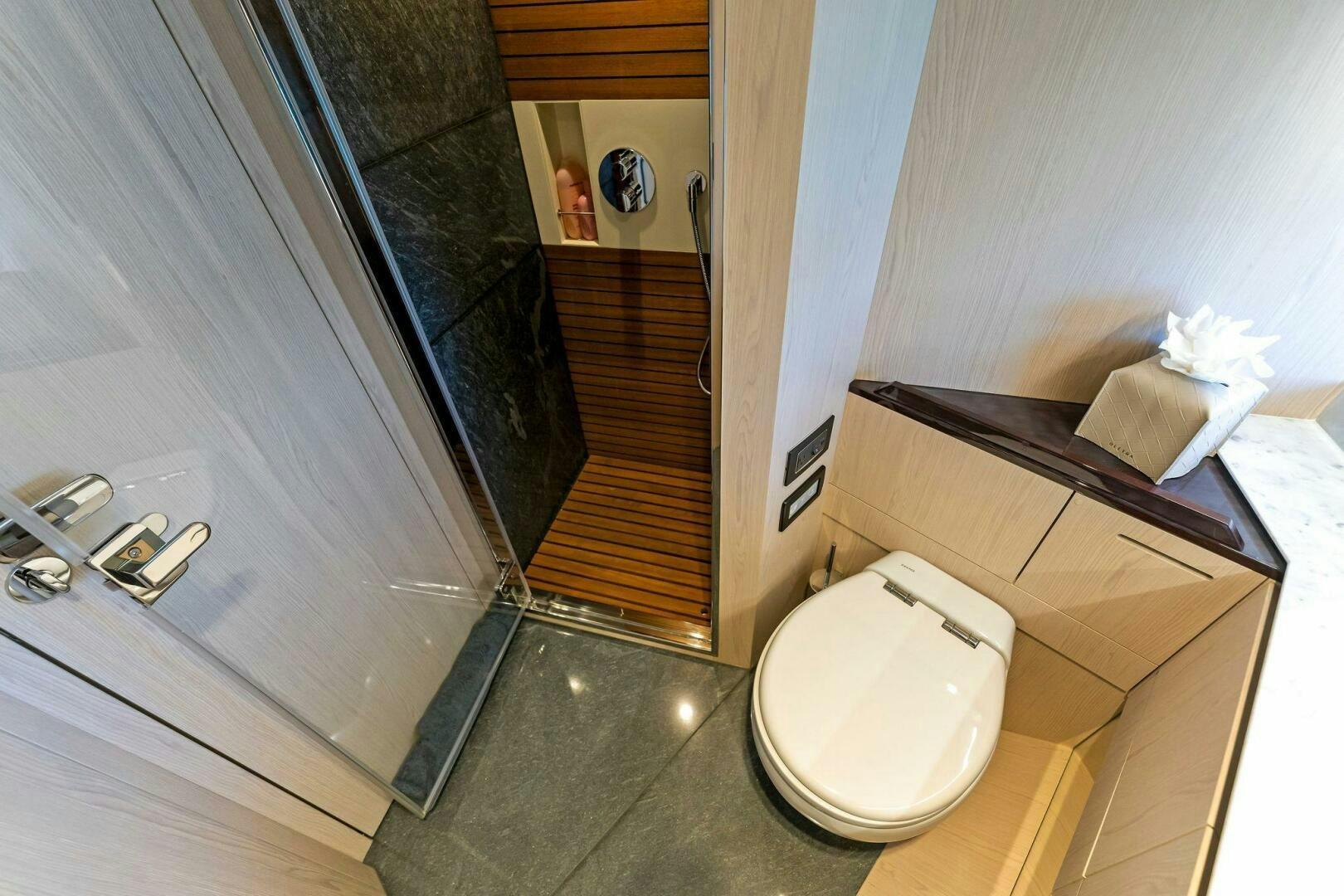 a bathroom with a toilet and a mirror aboard LIMITLESS Yacht for Sale