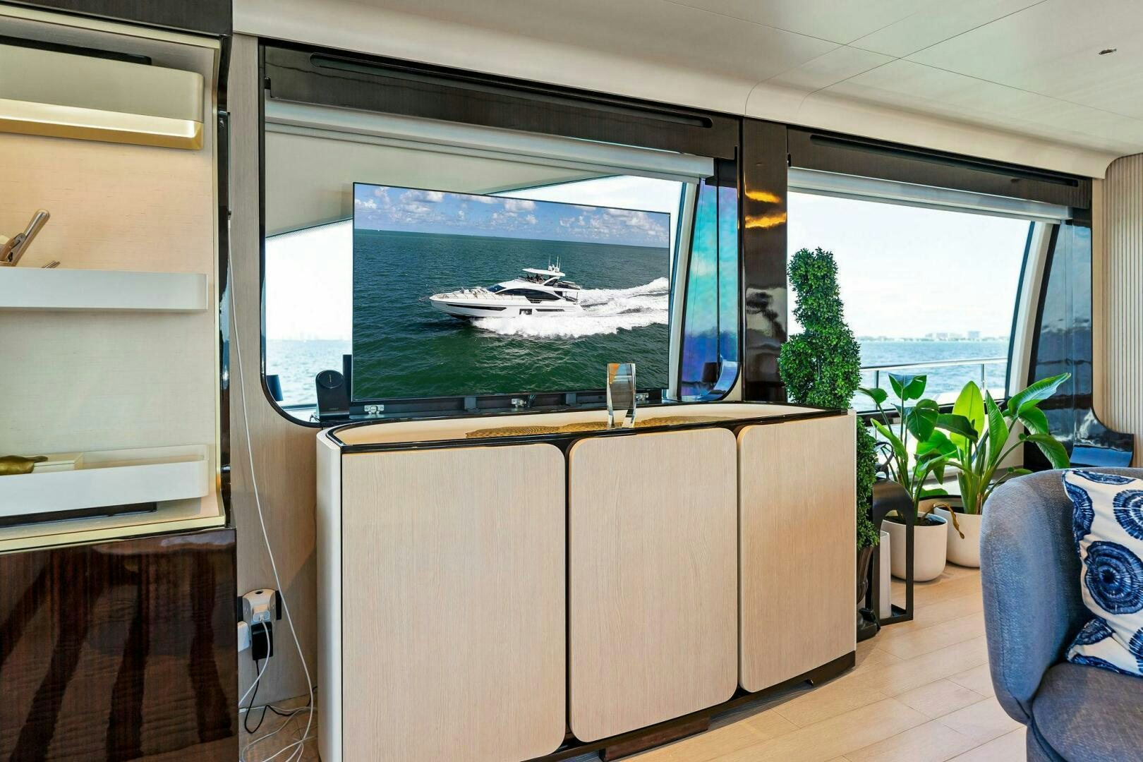 a room with a large window and a planter with a view of the water aboard LIMITLESS Yacht for Sale