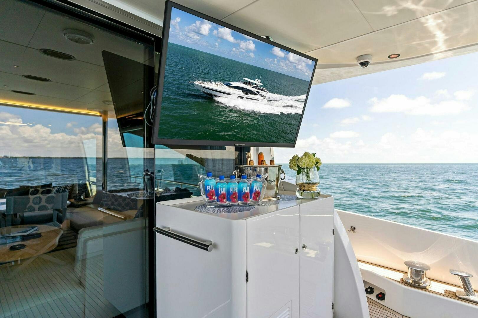a room with a tv on the wall and a sink with a view of the ocean aboard LIMITLESS Yacht for Sale