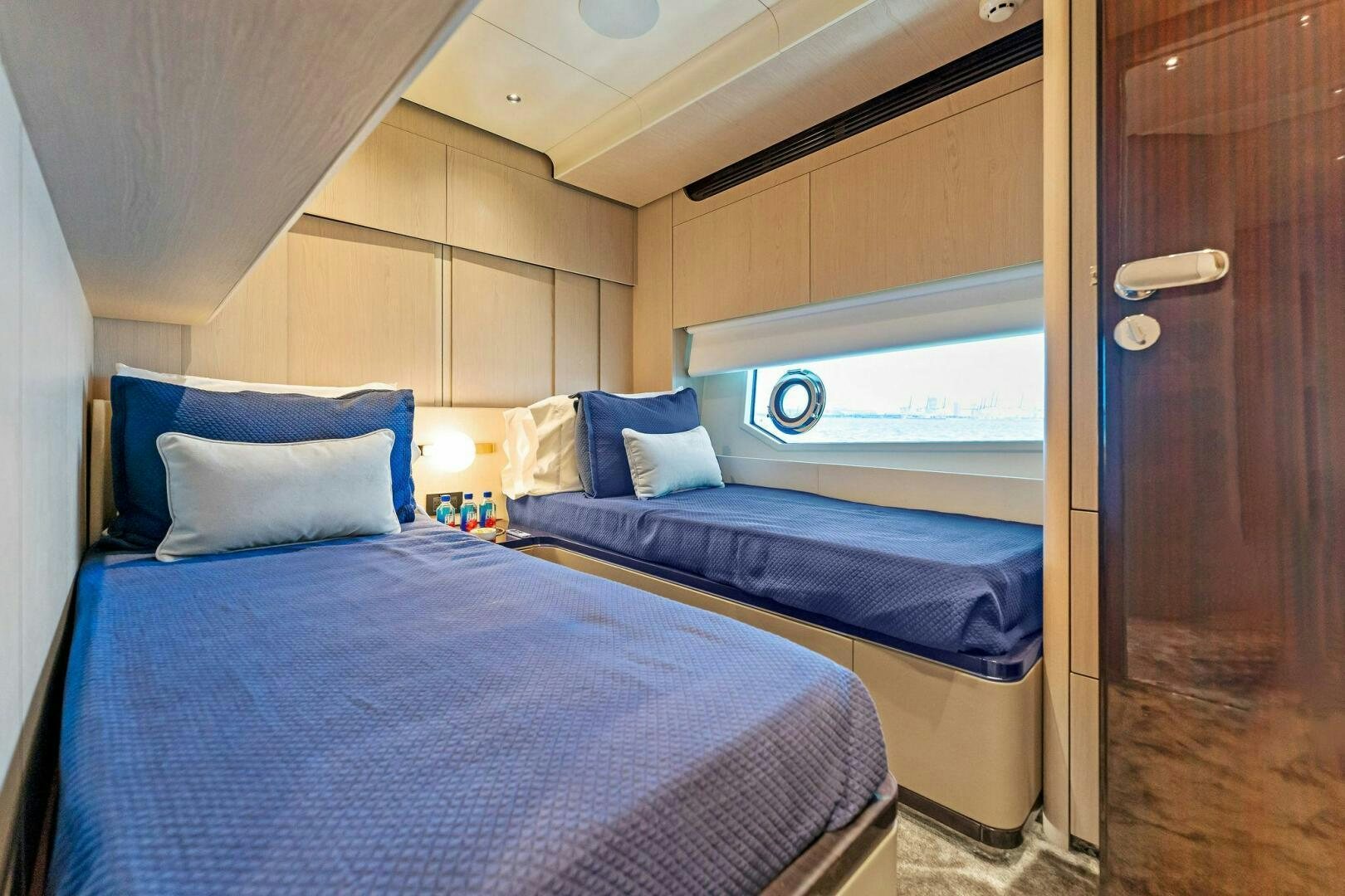 a room with a bed and a door aboard LIMITLESS Yacht for Sale