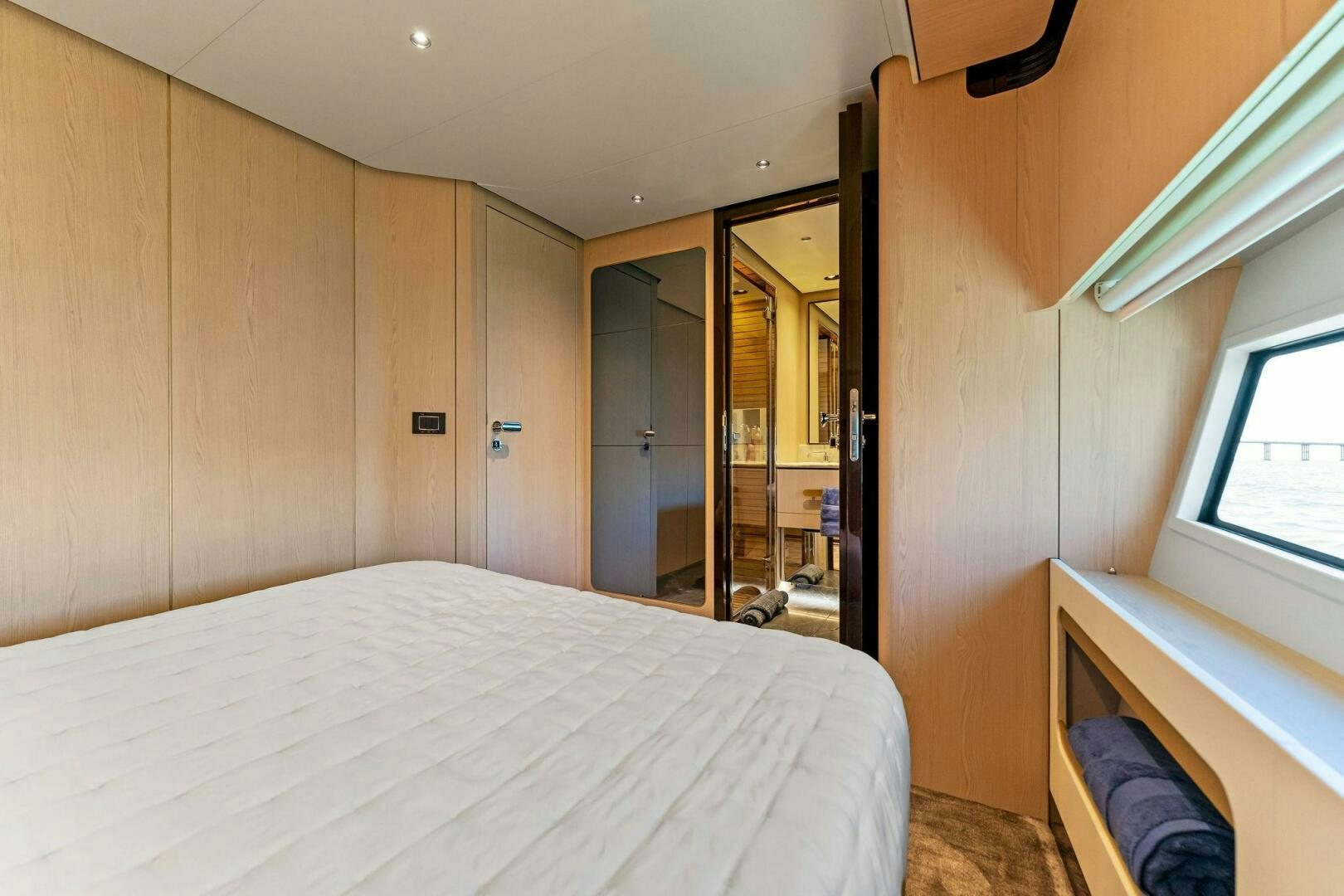 a bedroom with a bed and a closet aboard LIMITLESS Yacht for Sale