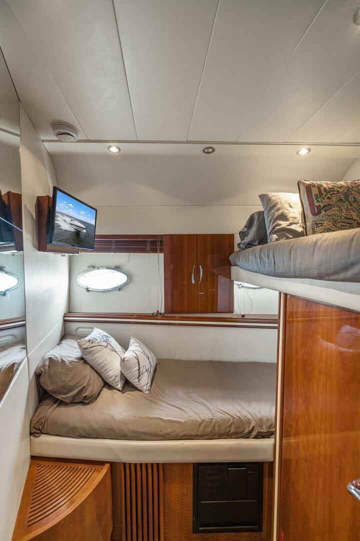 a room with a bed and a television aboard ROOSTERTAIL Yacht for Sale