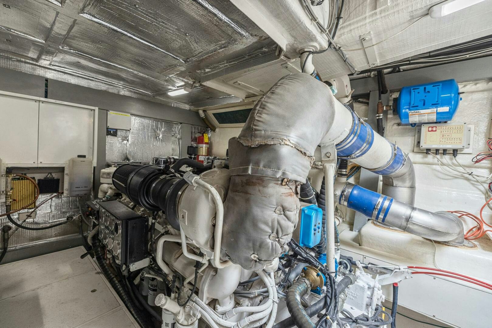 a person in a white coat working on a machine aboard ROOSTERTAIL Yacht for Sale