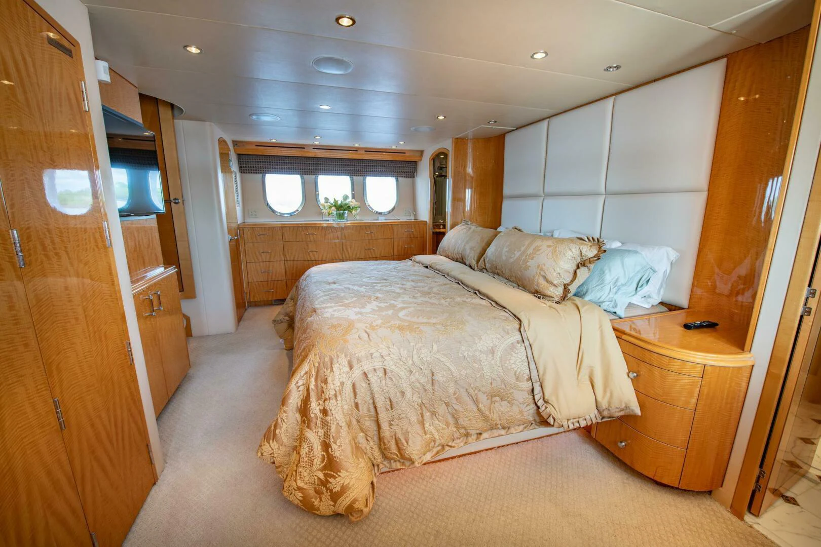 a bedroom with a bed and a dresser aboard TIME-2 FLY Yacht for Sale