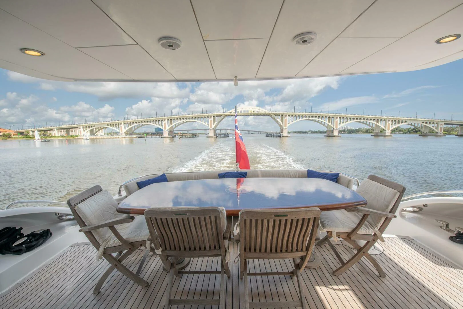 a table and chairs on a deck overlooking a body of water aboard TIME-2 FLY Yacht for Sale