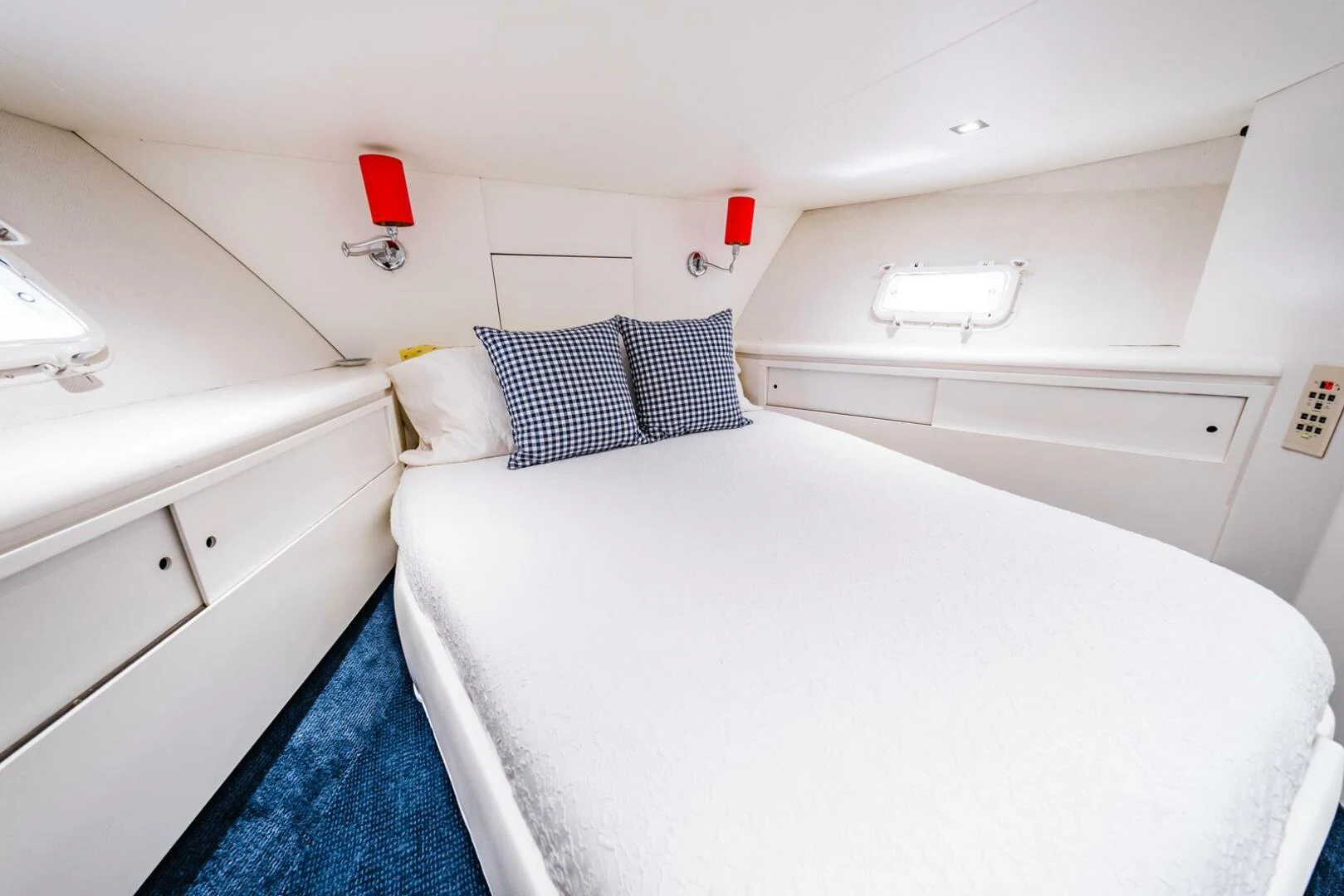 a white bedroom with a blue rug aboard GRACE Yacht for Sale