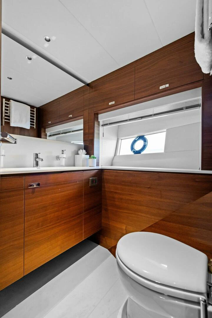 a bathroom with a toilet and a washing machine aboard RAW BAR Yacht for Sale