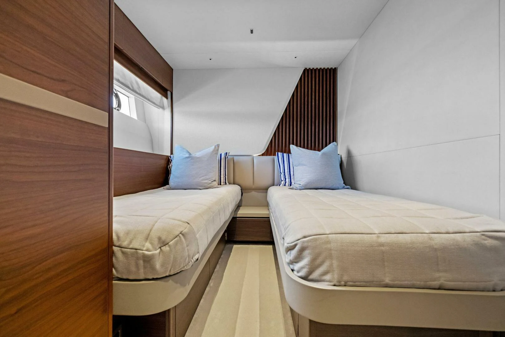 a room with beds and a striped rug aboard RAW BAR Yacht for Sale