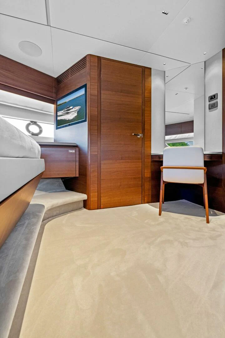 a room with a wood door and chairs and a tv on the wall aboard RAW BAR Yacht for Sale
