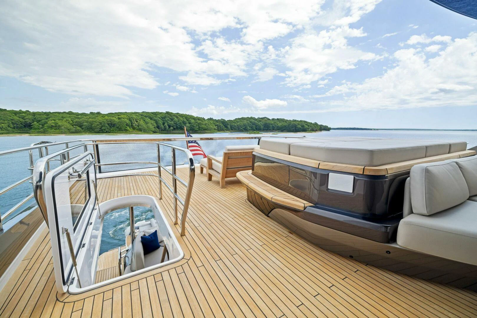 a deck with a boat and a flag on it aboard RAW BAR Yacht for Sale