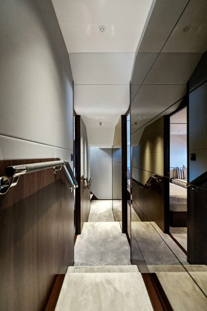 a hallway with a door and a railing aboard RAW BAR Yacht for Sale