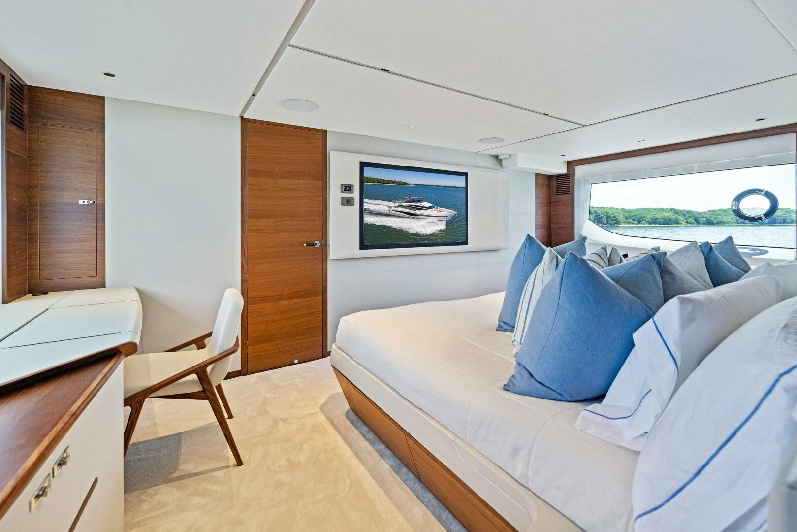 a bedroom with a bed and a chair aboard RAW BAR Yacht for Sale