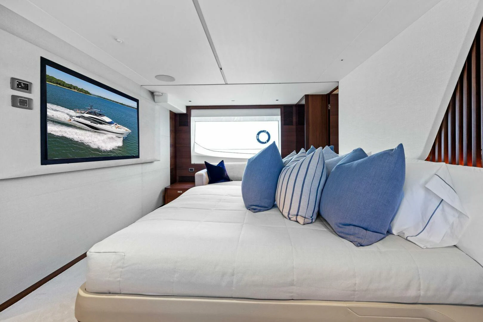 a bed with blue pillows aboard RAW BAR Yacht for Sale