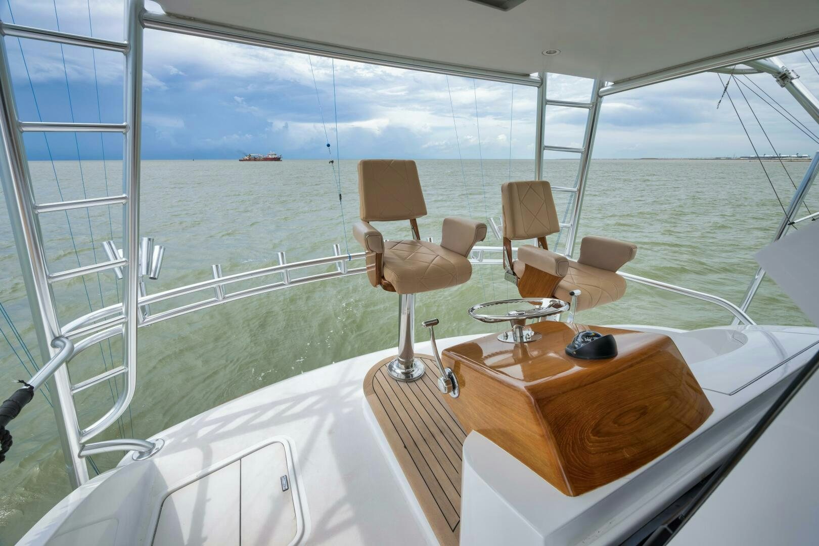 a room with a table and chairs on a balcony overlooking the ocean aboard LET  RIDE Yacht for Sale