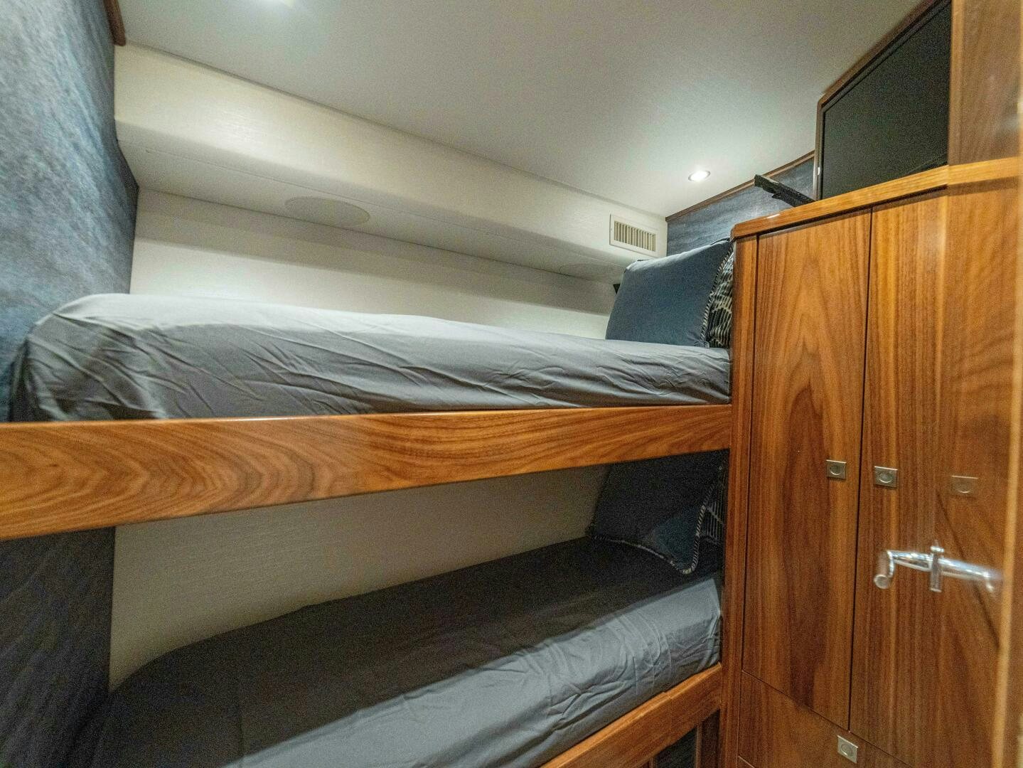 a bed with a wooden headboard aboard PURA VIDA Yacht for Sale