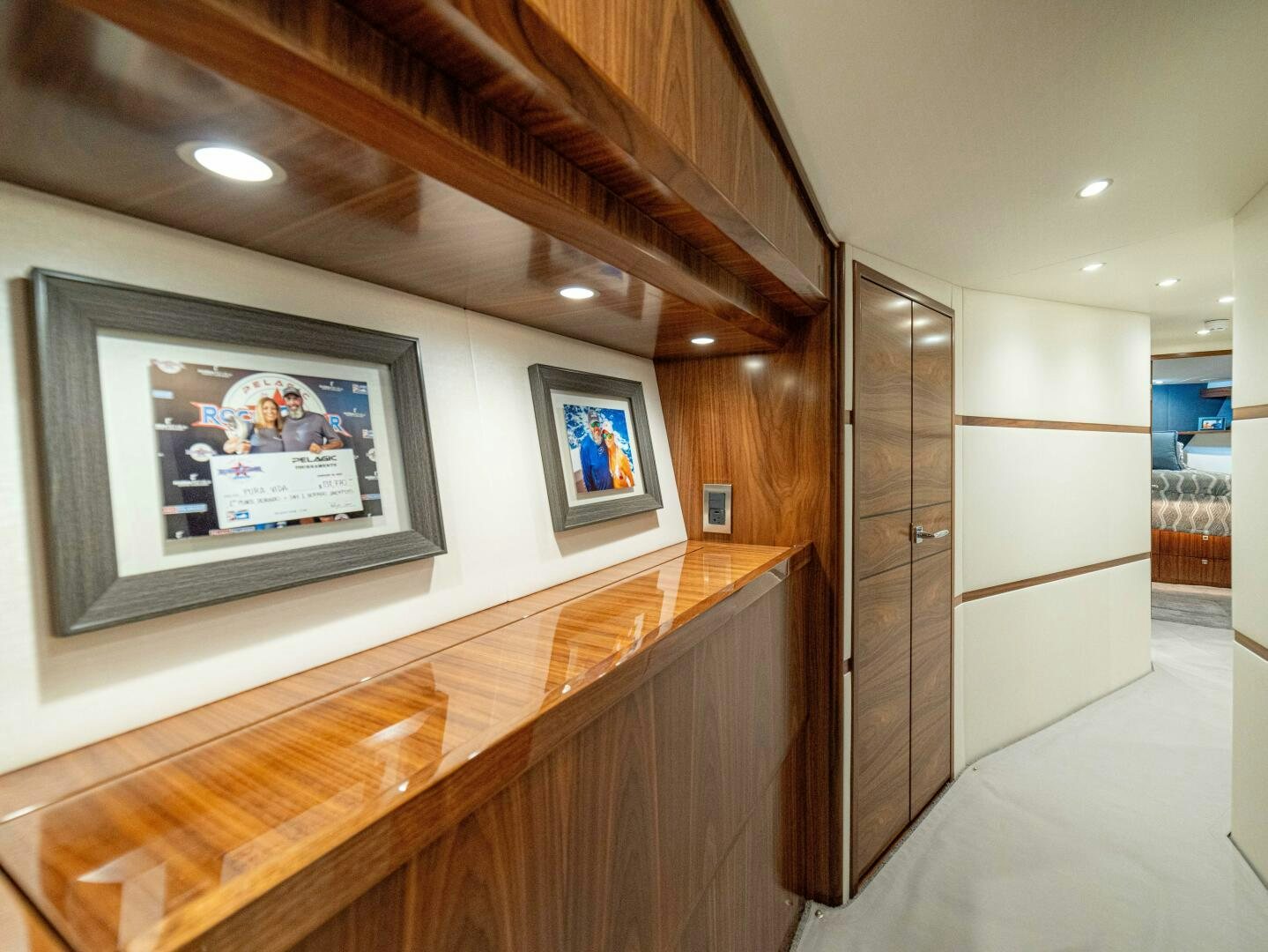a room with a wood wall and a wood floor with a large mirror aboard PURA VIDA Yacht for Sale