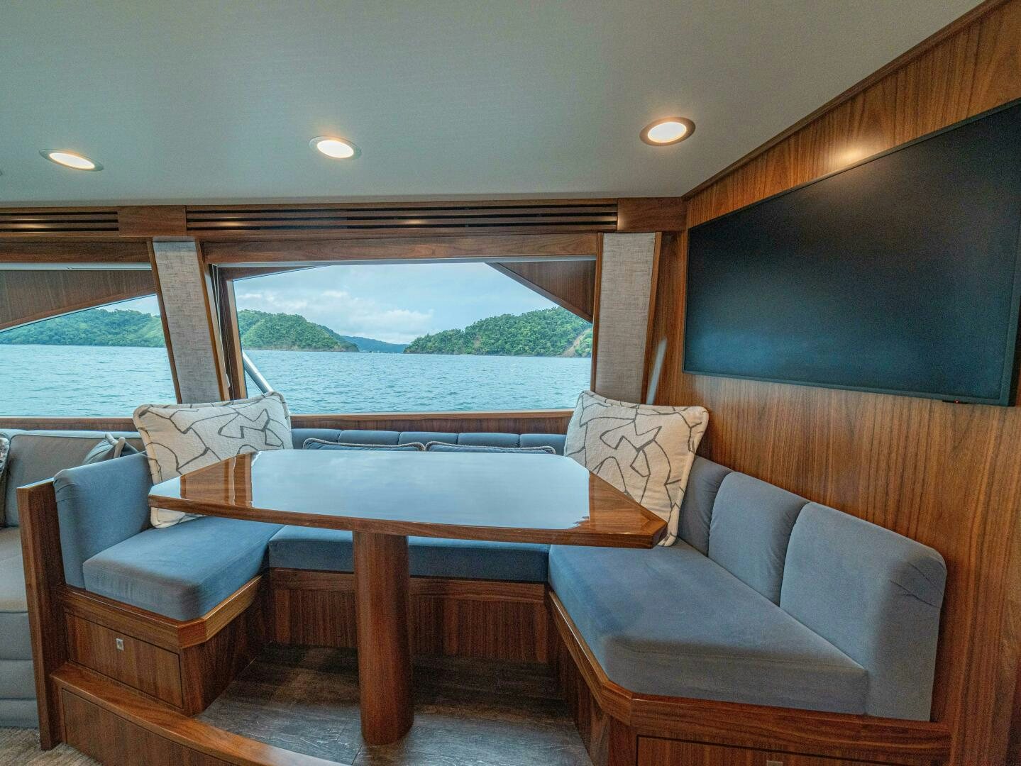 a living room with a table and couches aboard PURA VIDA Yacht for Sale
