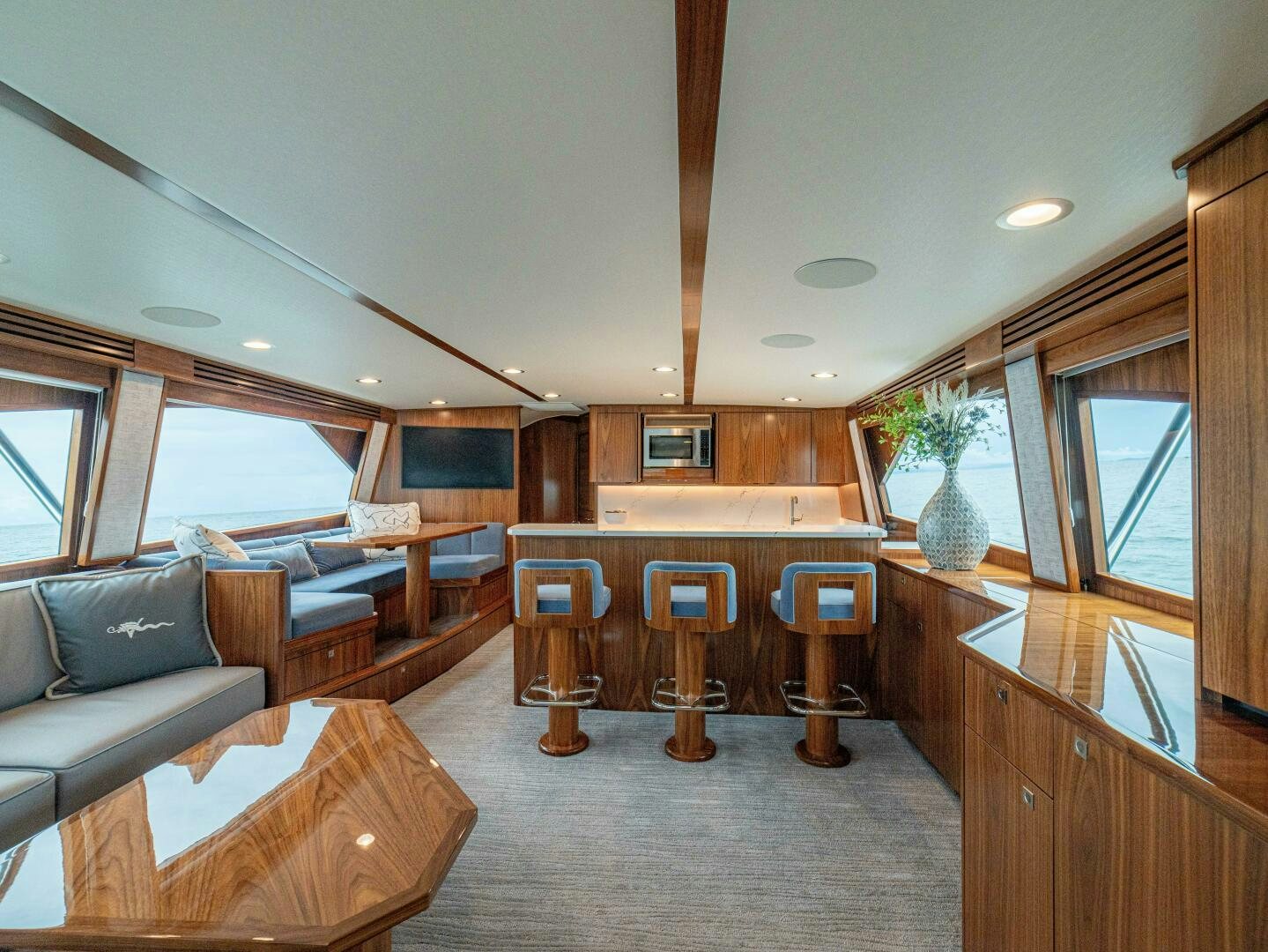 a living room with a wood table and chairs aboard PURA VIDA Yacht for Sale