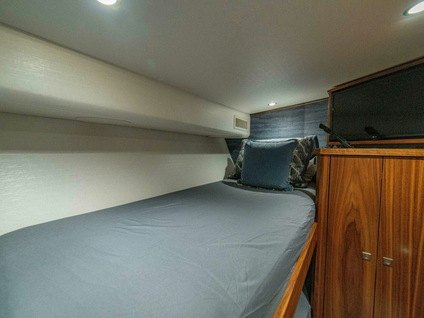 a bed with a blue comforter aboard PURA VIDA Yacht for Sale