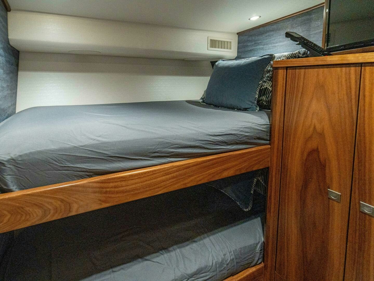 a bed with a wooden headboard aboard PURA VIDA Yacht for Sale