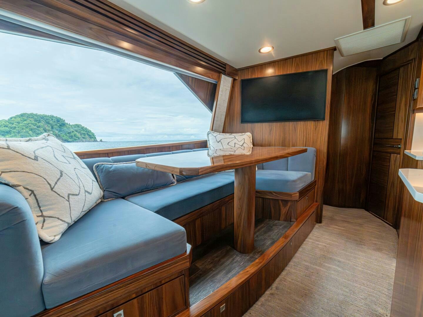 a room with a table and a couch aboard PURA VIDA Yacht for Sale