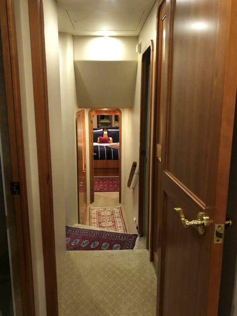 a hallway with a door and a rug aboard ENCHANTRESS Yacht for Sale
