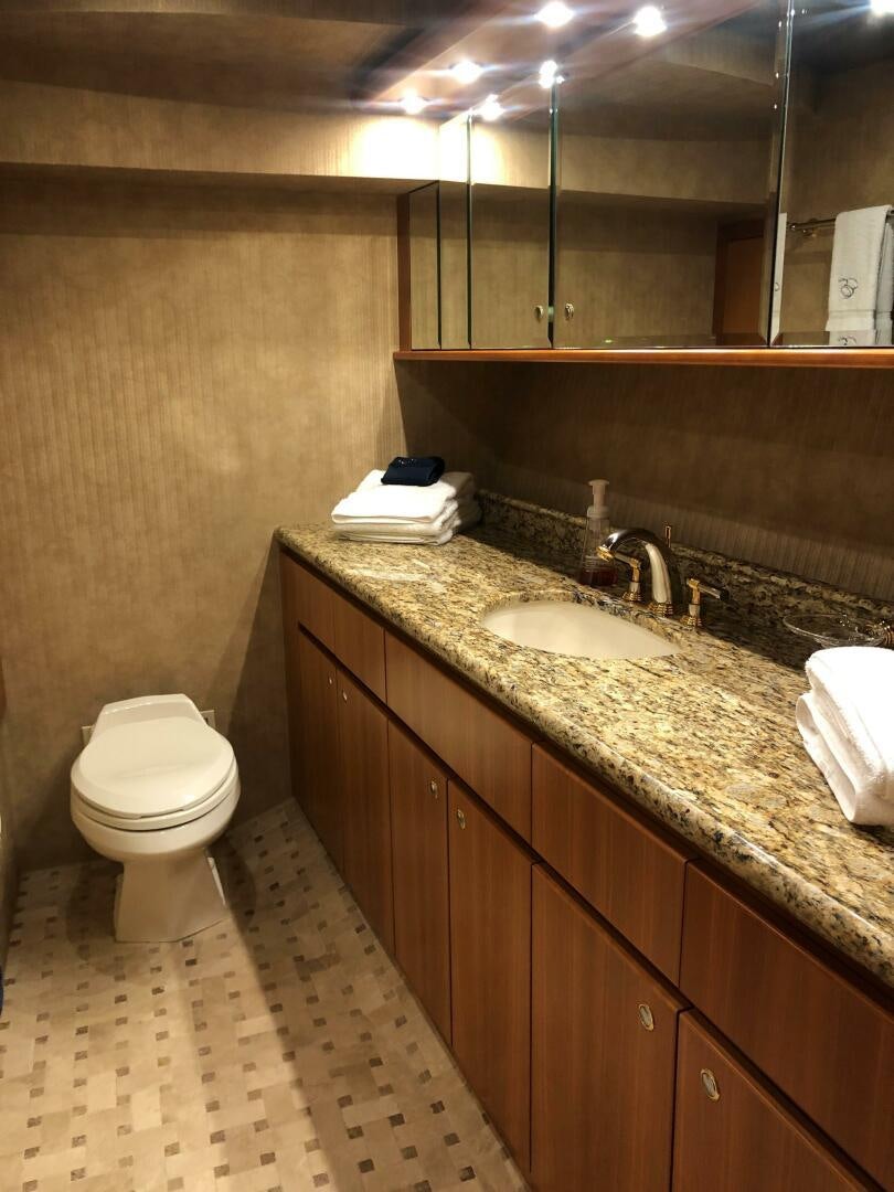 a bathroom with a countertop sink and a toilet aboard ENCHANTRESS Yacht for Sale