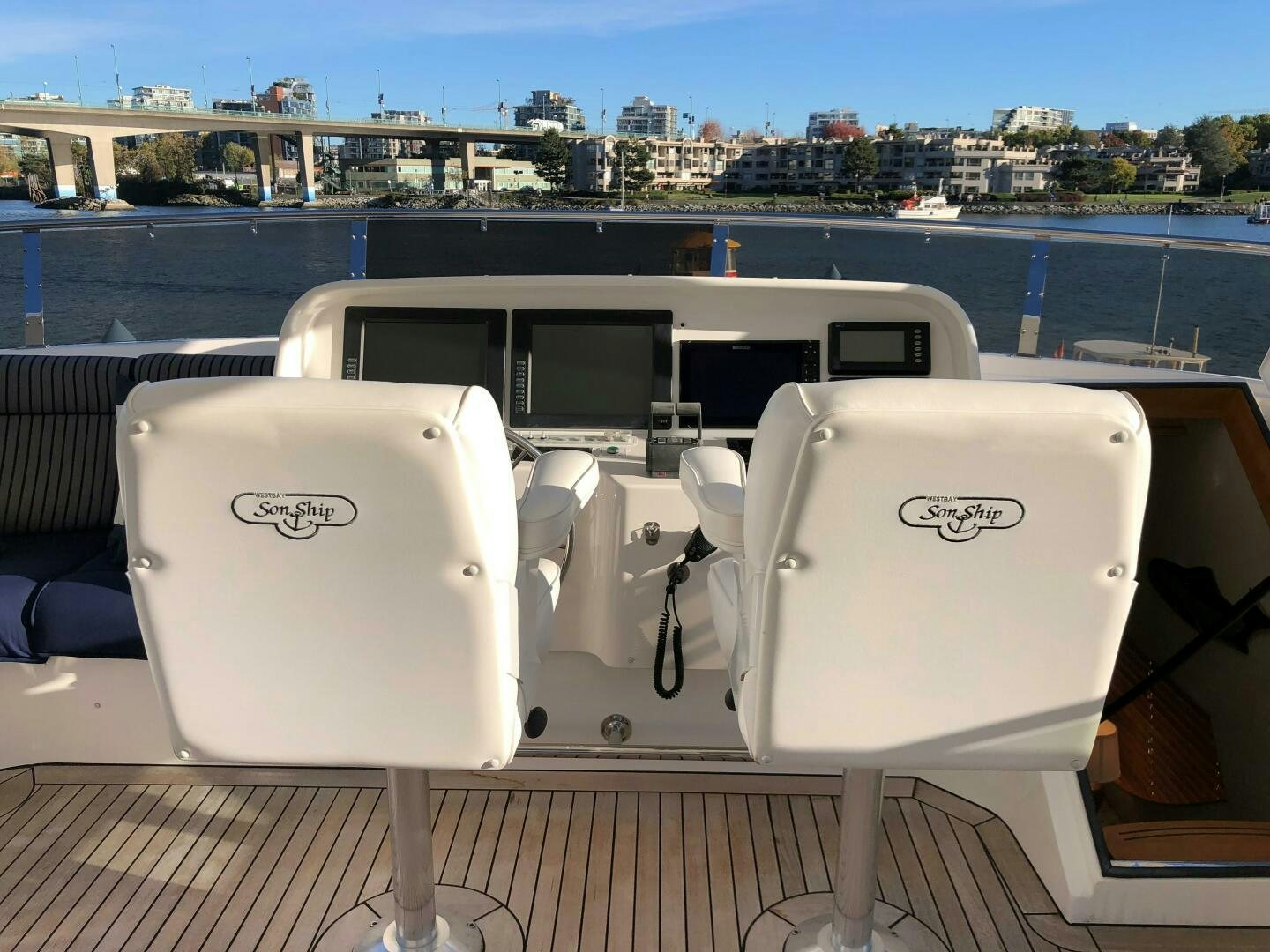 a white chair on a balcony overlooking a body of water aboard ENCHANTRESS Yacht for Sale