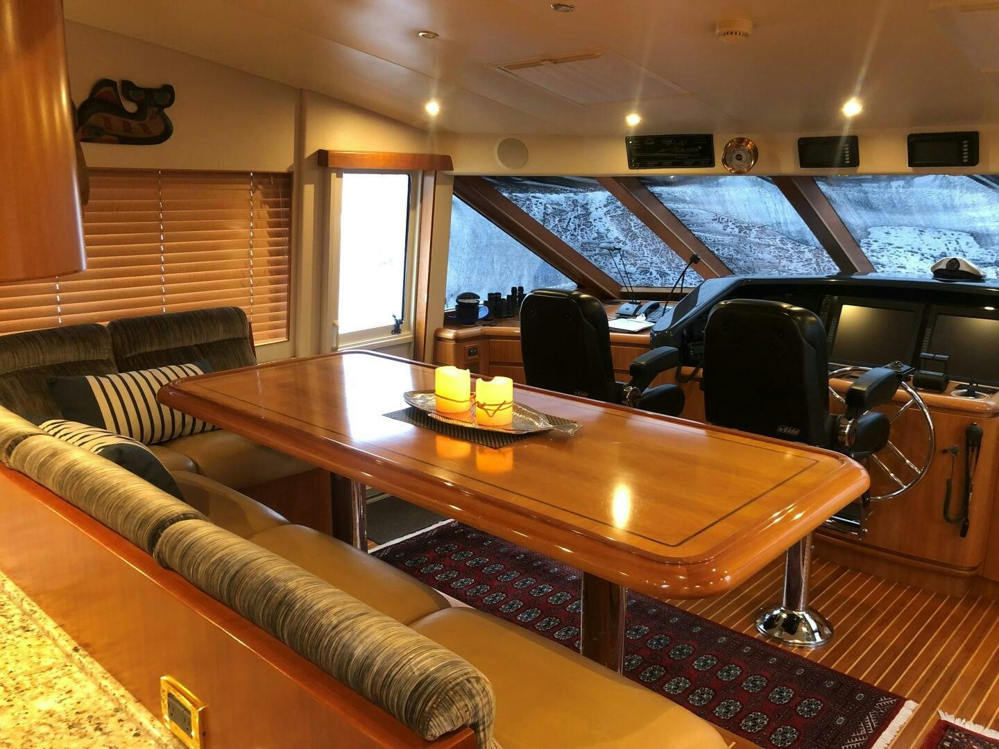 a table with a couch and a chair in a room with a large window aboard ENCHANTRESS Yacht for Sale