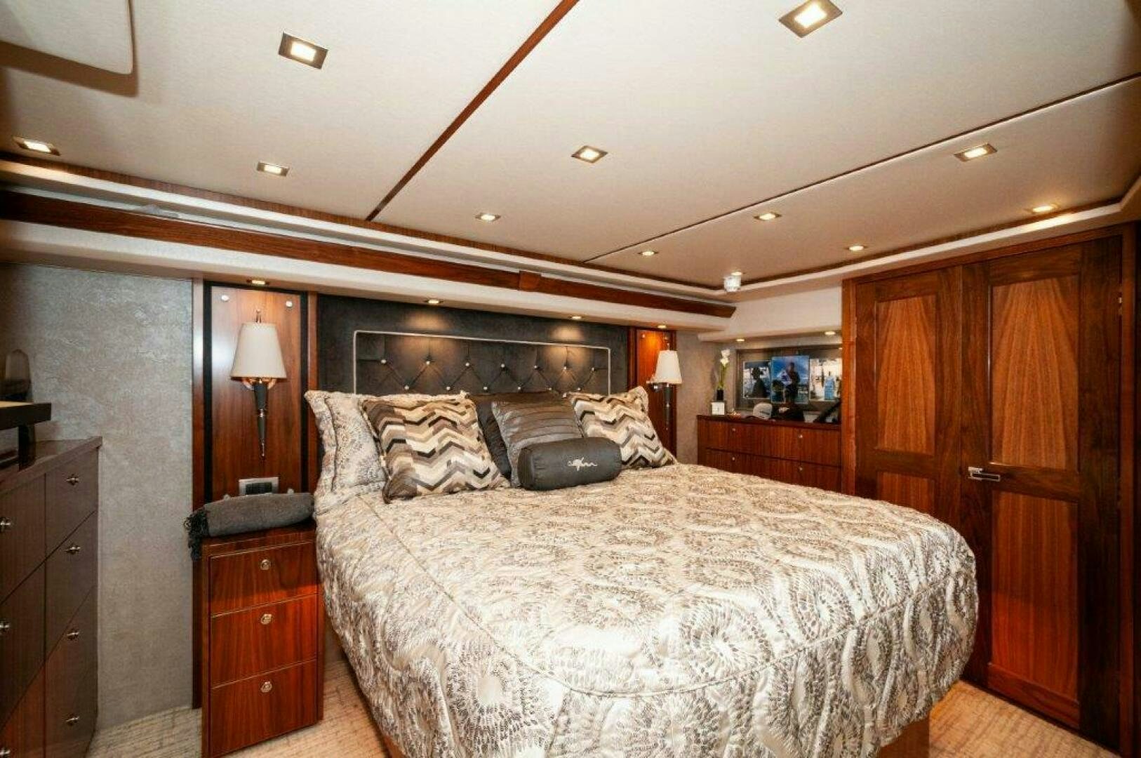 a bedroom with a bed and a wood cabinet aboard GUNNSLINGER Yacht for Sale