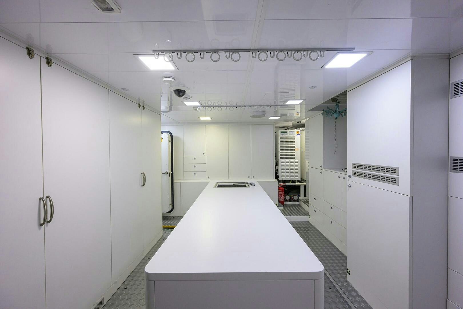 a long white counter with a few doors and a white wall aboard UPTIGHT Yacht for Sale