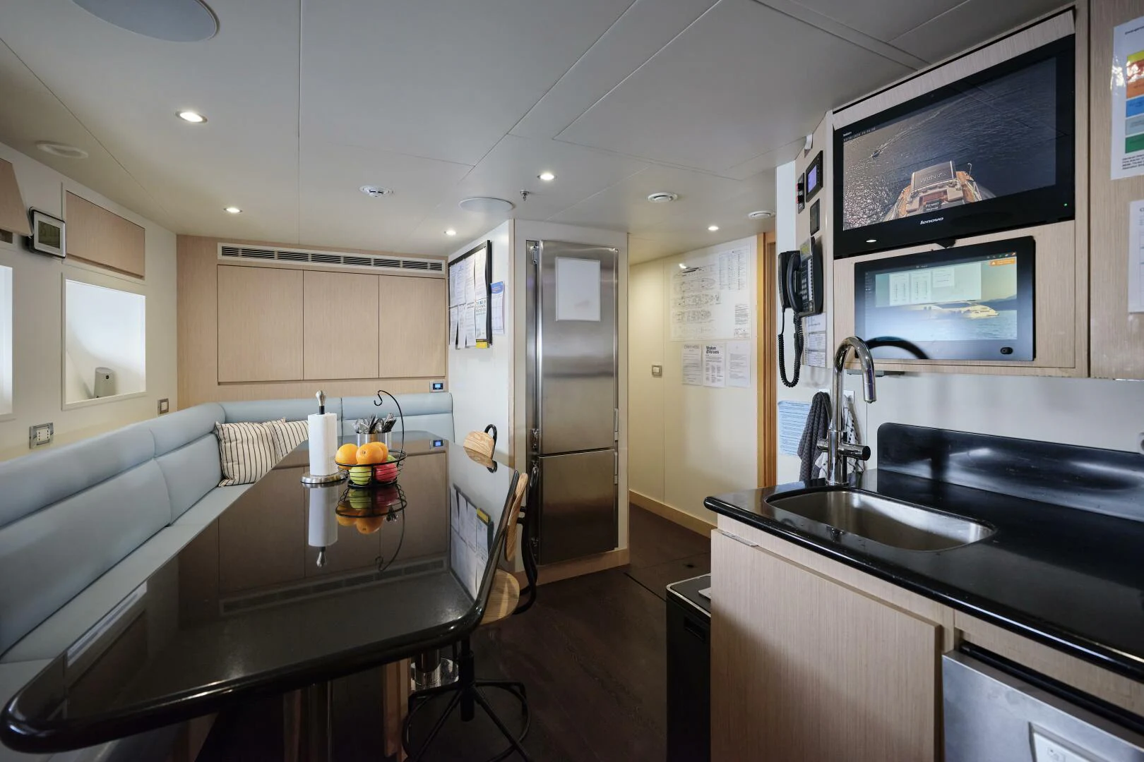 a kitchen with a table and a tv aboard SANAM Yacht for Sale