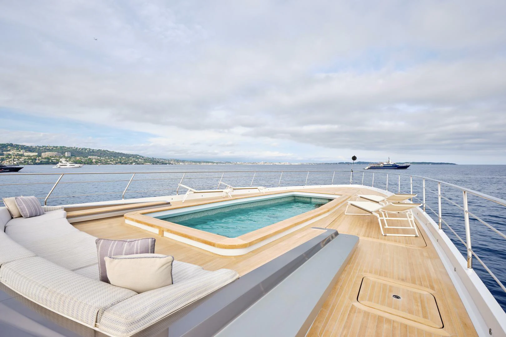 a deck with a pool and a view of the water aboard SANAM Yacht for Sale