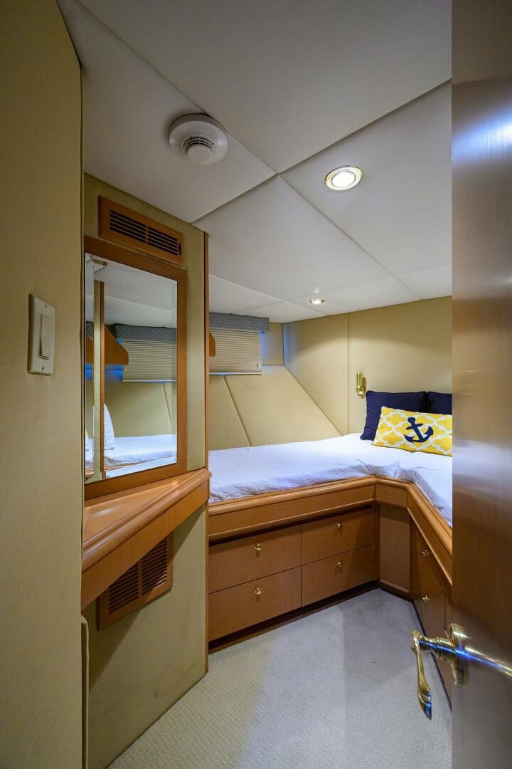 a bedroom with a bed and a mirror aboard BUSINESS TRIP 2 Yacht for Sale