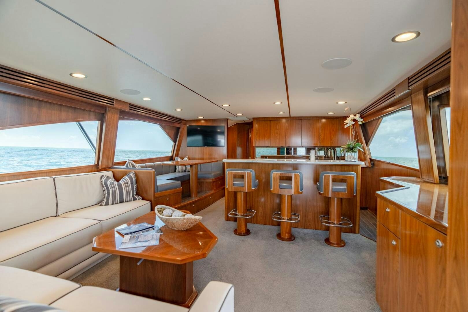 a living room with a kitchen and a bar aboard REEL CENTS Yacht for Sale