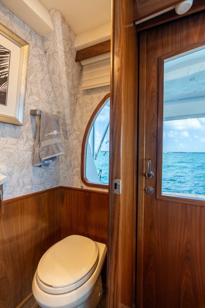 a bathroom with a toilet and a window aboard REEL CENTS Yacht for Sale