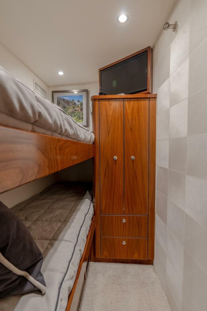 a bedroom with a bed and a television aboard REEL CENTS Yacht for Sale