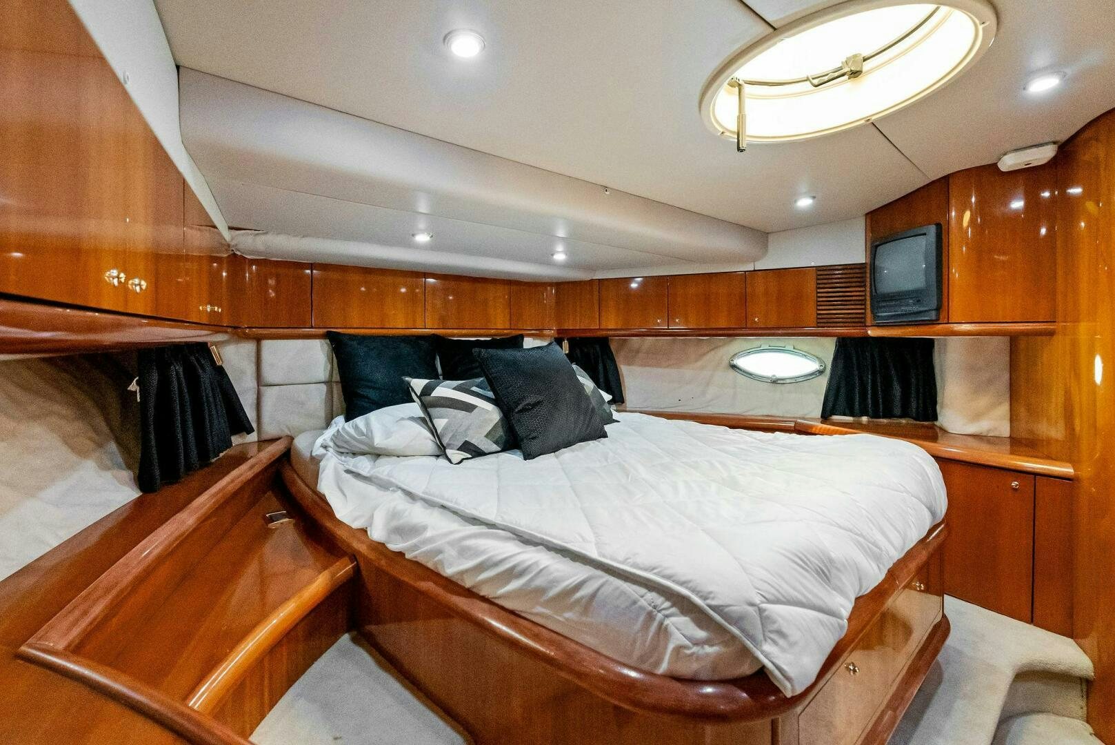 a room with a bed and a television aboard GAMBLER Yacht for Sale