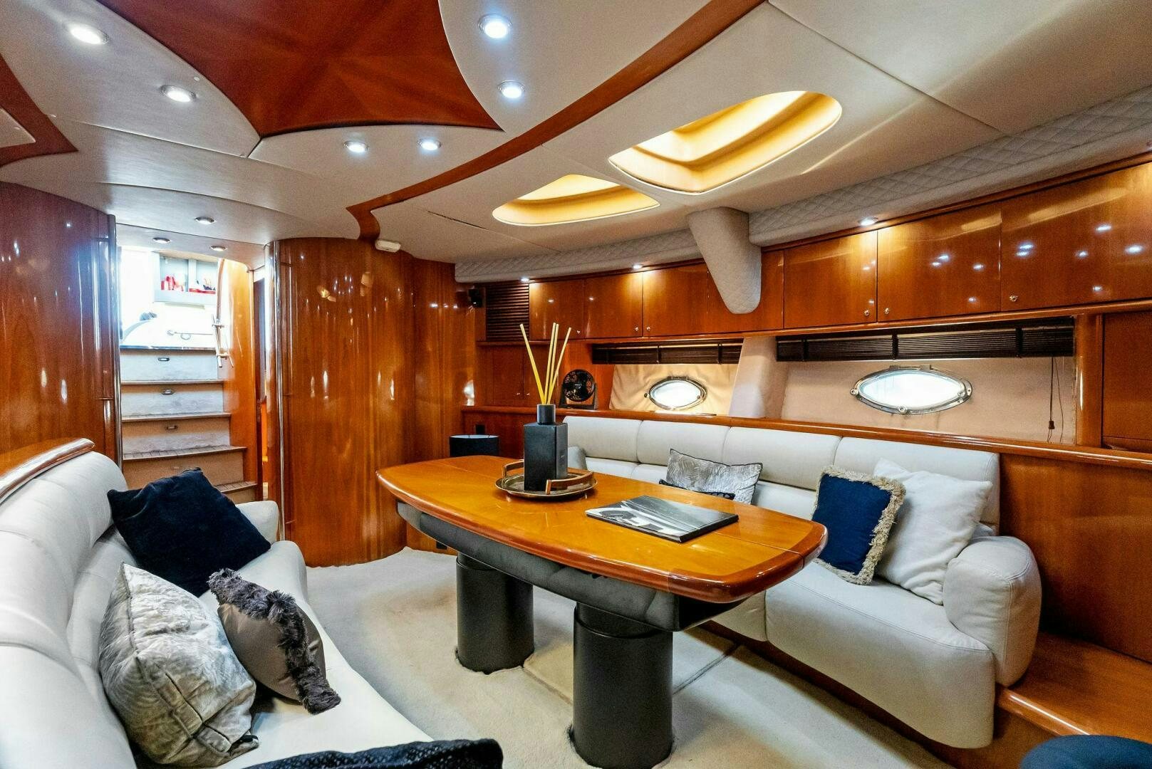 a living room with a table and couches aboard GAMBLER Yacht for Sale