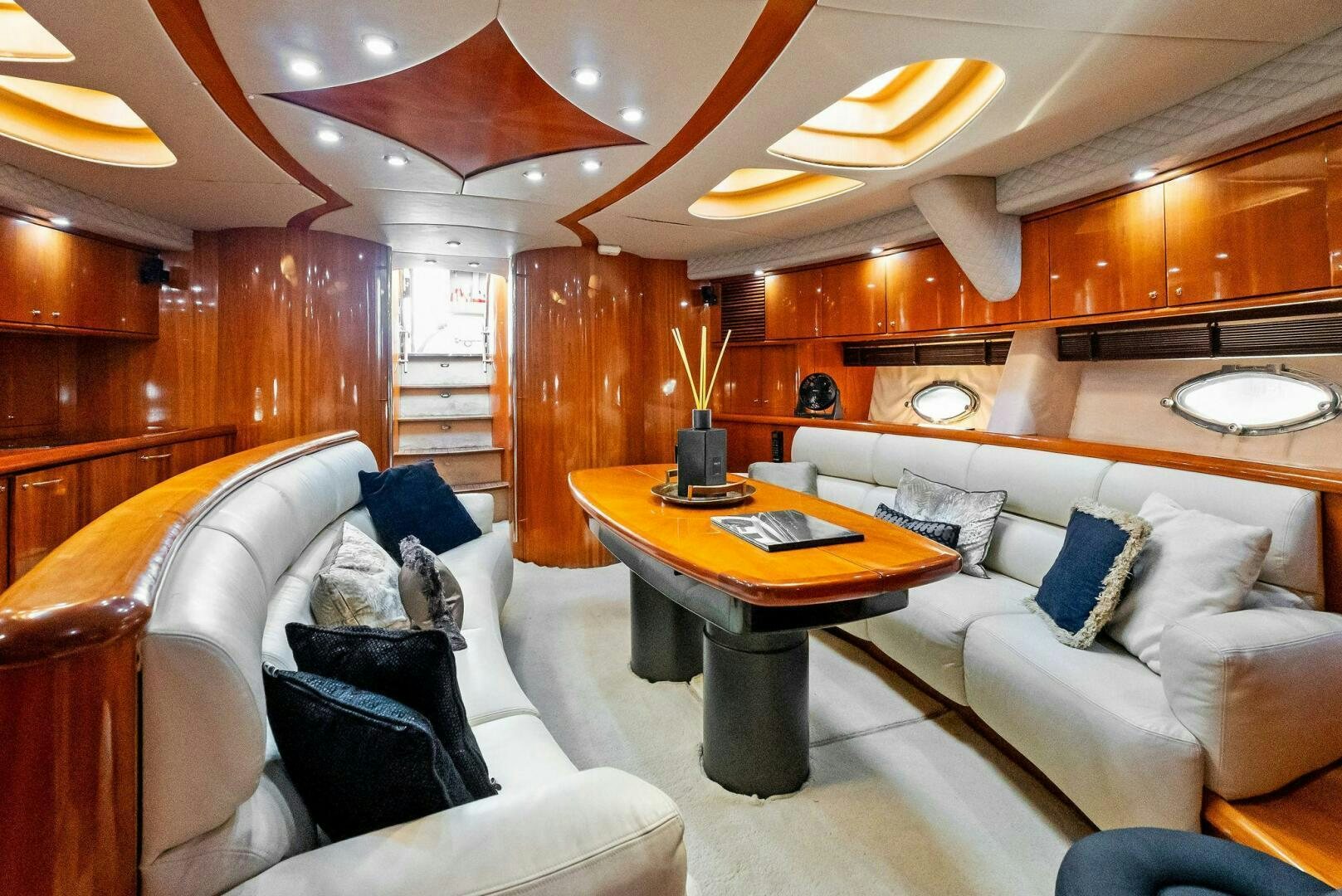 a room with a table and couches aboard GAMBLER Yacht for Sale