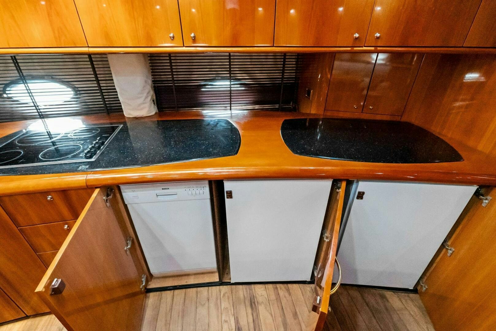 a kitchen with wooden cabinets aboard GAMBLER Yacht for Sale