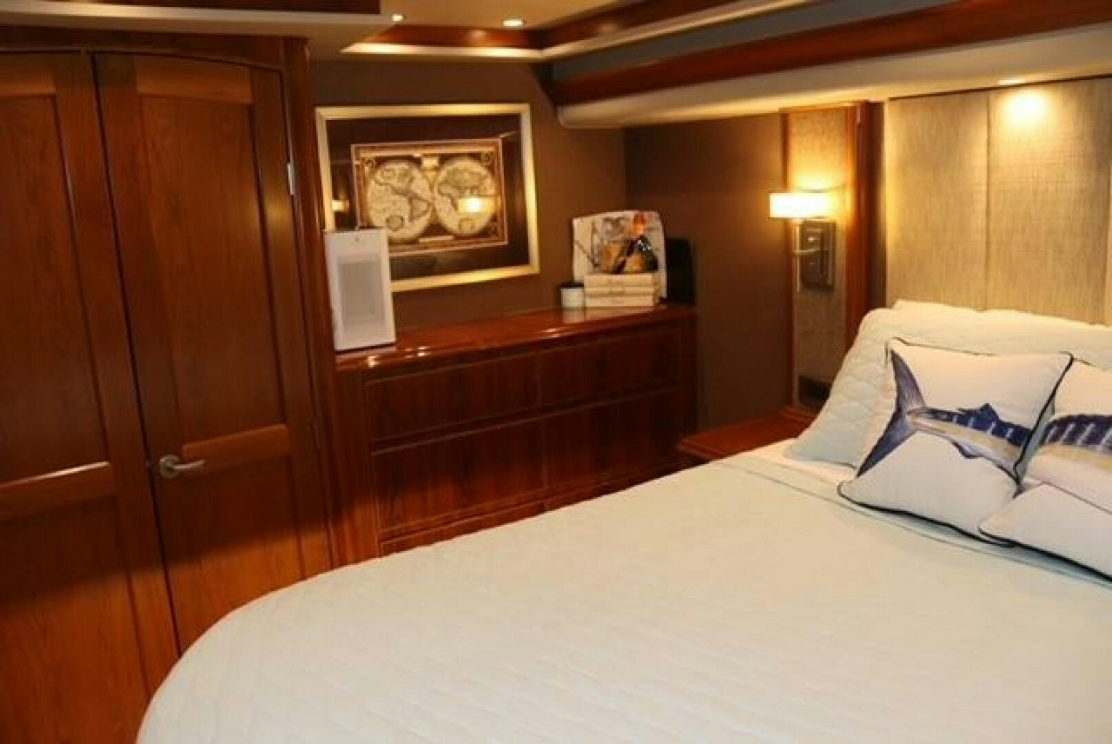 a bed with a white sheet and a wooden cabinet aboard BANDITO Yacht for Sale