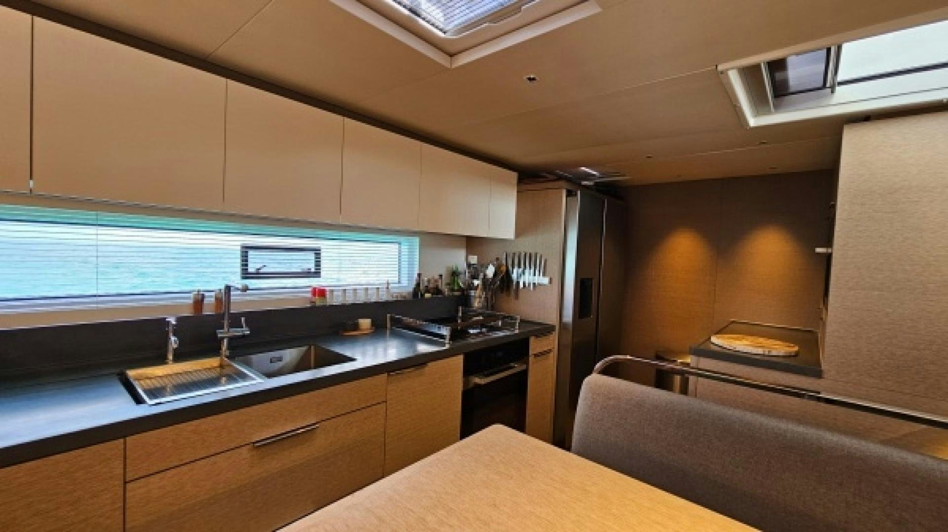 a kitchen with a sink and a refrigerator aboard SUNLOVE Yacht for Sale