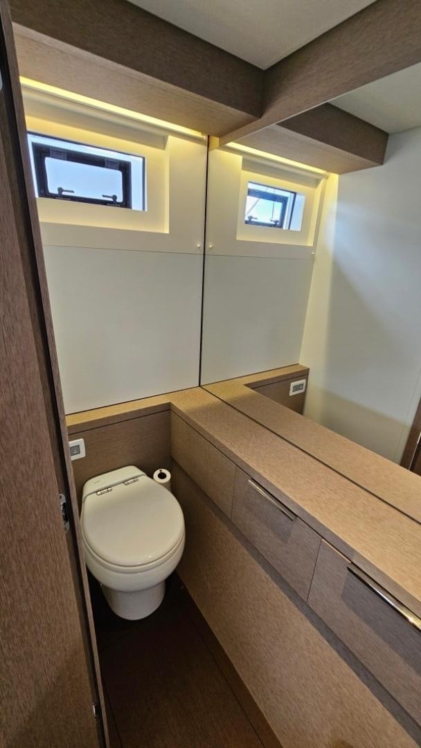 a bathroom with a toilet and a window aboard SUNLOVE Yacht for Sale