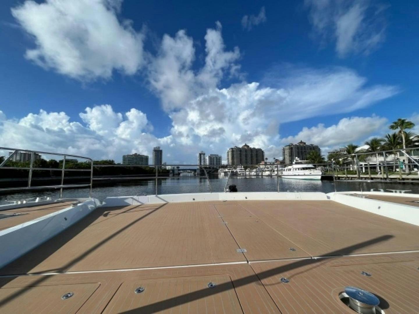 a boardwalk with a body of water and buildings in the background aboard SUNLOVE Yacht for Sale